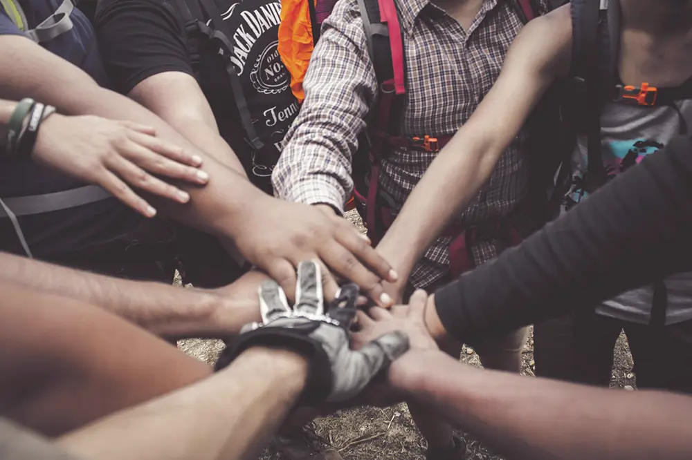 Manos de varias personas unidas en el centro